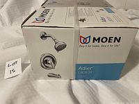 Box showing Moen brand, Adler model L82839, with image of showerhead and faucet, indicating single handle round wall mount unit with chrome finish.
