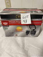 Image of unopened box showing brand and model, solar powered LED motion sensor light with 180 degree detection.