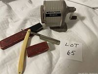 Photo showing vintage straight razor with cream handle, slightly corroded blade, and original red 'Corinthia' box, alongside the Sanford Giant pencil sharpener.