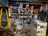 Overall view of various bar and spring clamps hanging on wooden rack