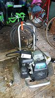 Front view of Honda 5.0 power washer on steel frame with wheels and coiled hose