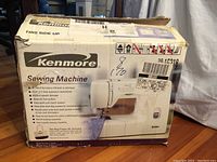 Photo of original cardboard box showing Kenmore branding and model number 15218 with picture of sewing machine.