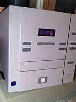 Front view showing display, stop/play buttons and disc drawer with Madrigal logo