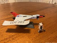 Photo of Avro jet model mounted on a black stand with astronaut figurine beside it