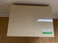 Top view showing rectangular flat surface, beige high gloss finish, green sticker with dimensions and lot number.