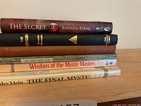 Spine view of stacked hardcover spiritual and inspirational books showing titles and authors.