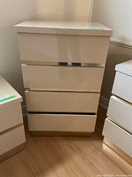 Photo showing front view of the white and gold dresser with one drawer slightly open.
