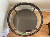 Top view of the round coffee table showing the clear glass top and wood frame.