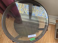 Top view of the round glass surface showing clear, transparent glass and reflection of ceiling window.