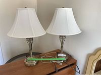 Pair of identical table lamps side by side showing full view including cords and shades.