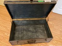 Open vintage trunk showing worn textured interior lining