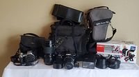 Overall view of entire camera lot with cameras, lenses, bags and Ion film scanner box