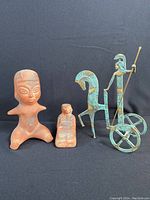 Three figurines: metal Athena chariot with horse and two vintage red sandstone clay figurines