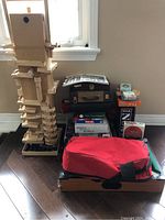 Full view of lot showing wooden block set, board games stacked, and mini pool table in bag.
