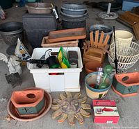 Photo of the entire garden lot showing assortment of planters, trays, containers, garden decor sun plaque, hummingbird feeders, and the white storage bin with garden tools and items.