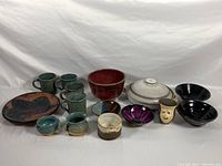 Full view of all pottery items in lot displayed on white background.