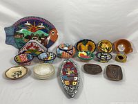 Image showing entire pottery lot on white background, including large colorful fish platter and various small bowls and dishes