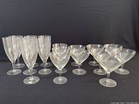 Full set of 16 clear stemware Rosenthal Claudia claret glasses shown in groups by size.