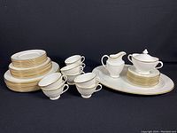 Full overview of eight dinner plates, eight salad plates, eight cups and saucers, sugar bowl with lid, creamer and oval platter