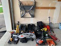 Overview of lot on garage floor showing tools, cases, containers and accessories