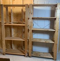 Two wooden shelving units side by side, showing natural wood finish and construction style with cross braces at the back.