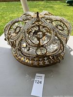 Antique light fixture showing brass frame and clear crystal decorations from above point of view.