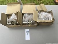 Three boxes containing new door handle sets partially wrapped in bubble wrap.