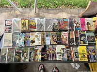 Overview of 28 paperback books on glass table