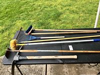 Seven yard tools laid on a black table outside on grass