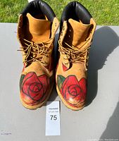 Front view of Timberland boots with artist painted large red roses on front toe caps.
