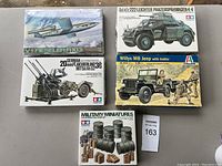 Lot of five brand new military model kits arranged in two rows on flat surface.