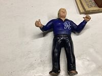 Front view of Bobby 'Brain' Heenan wrestling action figure in blue top and black pants, showing wear and paint chips.