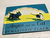 Front cover of the book showing title and illustrations of black dog and black and white cat.