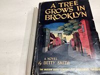 Front cover of the 1944 edition of 'A Tree Grows in Brooklyn' showing the illustrated dust jacket with noticeable wear and creases.