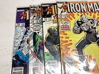 Four Iron Man comic books showing various covers and the Marvel branding.