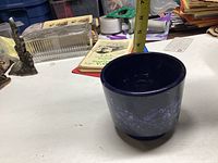 View showing the full vase standing about 4 inches tall with a dark blue drip glaze pattern.