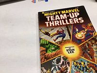 Photo of the front cover of a Mighty Marvel Team-Up Thrillers comic book featuring Marvel superheroes like Hulk, Spider-Man, and Iron Man.