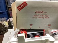 Box showing 'Fragile' label and Coca-Cola branding showing it's a die-cast metal replica of the 1938 delivery truck.