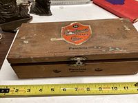 Top view of closed wooden cigar box with Pandora cigar labels and visible wear.