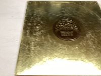 Gold-colored vinyl record cover with embossed star logos and text 'Barry White's Greatest Hits'