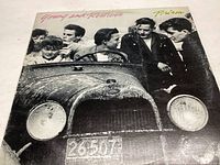 Front cover of the vinyl record sleeve showing the band members around a vintage car with license plate, titled 'Young and Restless Prism'