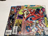 Three Spider-Man comics fanned out on a white surface showing the covers and spine details.
