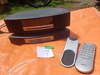 Two stacked modules on orange tarp with cables and remotes in view