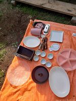 Full overview of all kitchen items laid out on orange tarp outdoors.