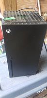 Exterior of Xbox Mini Fridge showing black body and perforated top panel with Xbox logo.