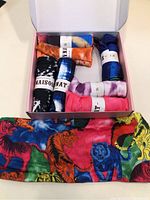 Top view of eight headbands in original box, showing assorted colors and tie-dye patterns