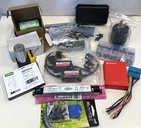 Overview shot of the lot showing multiple electronic components, adapters, connectors, and boxed items arranged on a white surface.