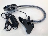 Photo showing black clip-on grow plant light with flexible neck and attached power cord with inline switch