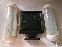Top view showing two solar light units and a connected black solar panel control with wiring.