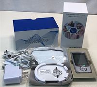 Full kit including Schiara muscle massager device, electrodes, charger, pouch, and boxes.